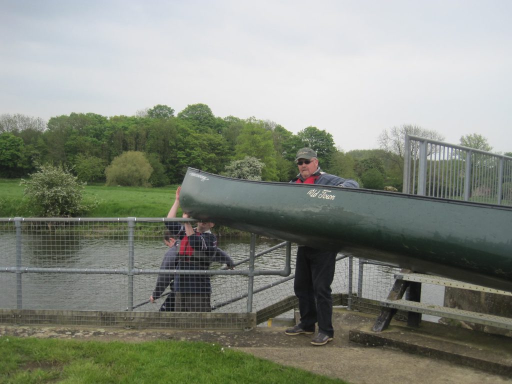 Greame carrying his canoe to the water